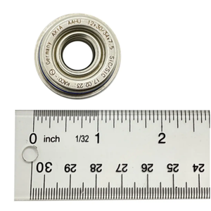A Polaris Seal, Wp Shaft is shown above a ruler marked in inches and centimeters for scale. The seal features engraved text on its edge and its diameter appears to be slightly over 1 inch.