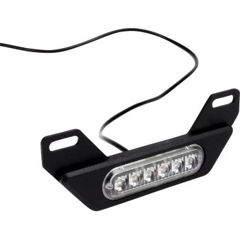 The Denali Brake Light - B6 features a compact black LED bar with six bulbs and a clear cover, designed for license plate mounting. It comes on a bracket with two mounting holes and includes an attached black wire.