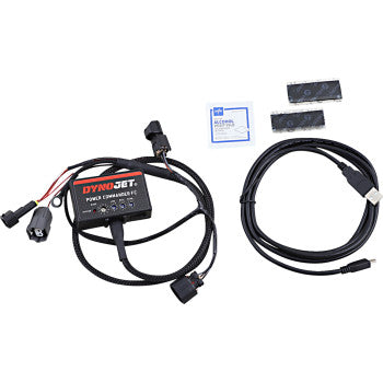 The Kawasaki Power Commander Fuel Controller by Dynojet kit includes the main module with cables, USB cable, two memory chips, and a small packet on a white background. Supports custom Dynojet maps for your bike. Plug-and-play installation.