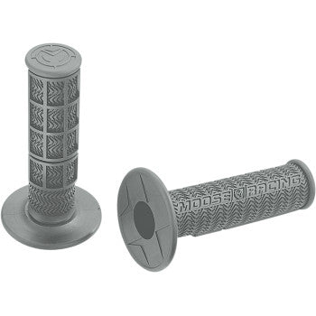 Two Flange Style Stealth MX Grips in gray by Moose Offroad: one upright, showing a chevron-patterned high-traction surface; the other lying down, displaying "Moose Racing" text and a round flange at one end.