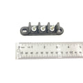Black plastic 3-post terminal block with metal screw connectors next to a ruler for size.