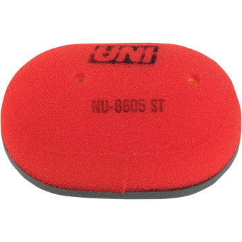 The Arctic Cat Air Filter by Uni Filter is a red oval foam filter with two small holes, black edges, and UNI NU-8605 ST printed on top to ensure maximum airflow and enhanced engine performance.
