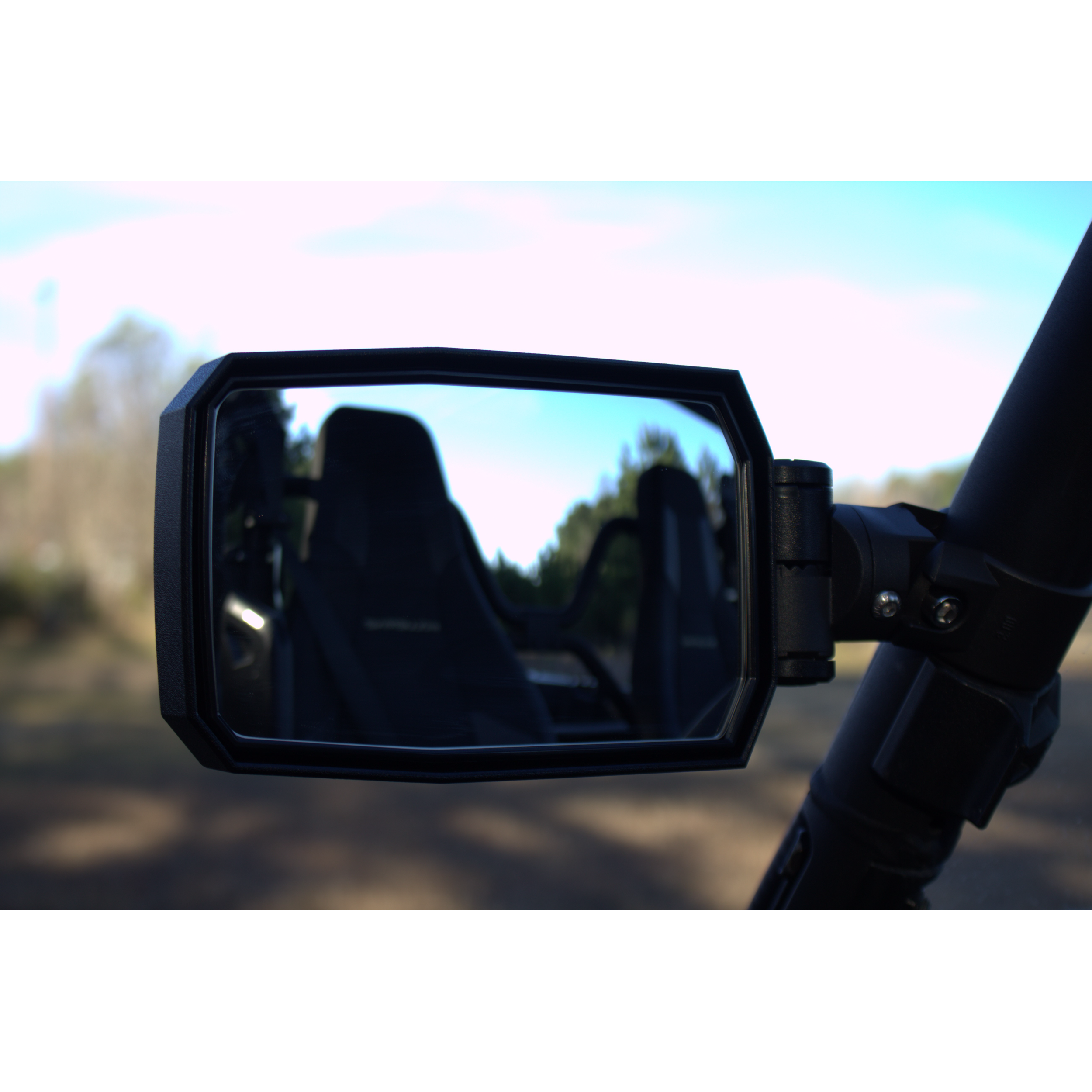 Close-up of the Seizmik Pursuit Side Mirror for Can-Am, Polaris, Honda, John Deere, and Kawasaki vehicles featuring shatter resistant glass, reflecting the empty passenger seat and blurred trees under a clear sky.