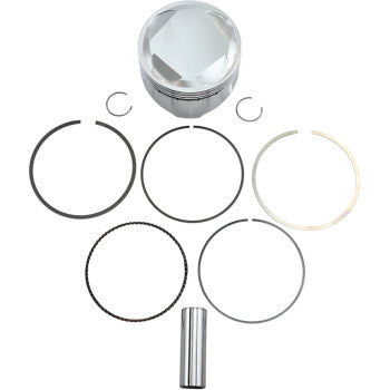 The Honda Piston Kit 85.50 mm by Wiseco is shown on a white background, including a silver piston, five rings, two circlips, and a cylindrical wrist pin arranged neatly in a flat lay.