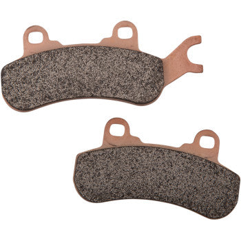 Pair of curved rectangular off-road brake pads with copper-colored metal backing and textured friction surfaces.