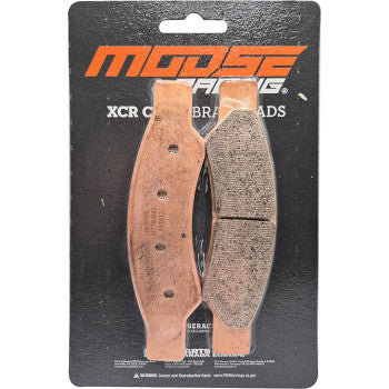 Copper-colored metal and textured friction material brake pads on black Moose Racing branded backing card.