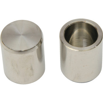 Two cylindrical metal brake caliper pistons with smooth polished surfaces, one showing the solid top and the other an open.