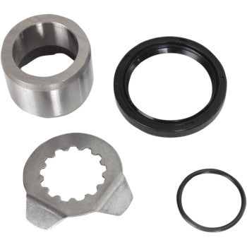 Metallic silver output countershaft seal collar, black rubber seal ring, gear-shaped metal retainer, and small black rubber.