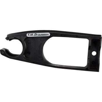 The Yamaha Raptor Front Chain Slider Black by T.M. Designworks is a durable composite black plastic chain guide with a rectangular cutout and a T.M. Designworks logo sticker on top, designed for enhanced wear life.