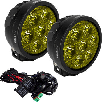 The Light Cannon Spot Beam Selective Yellow Lens by Vision X includes two round yellow LED off-road lights with black housings, selective yellow lenses, and a wiring harness with connectors, all designed for vehicle installation.