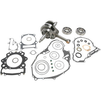 Metal Yamaha crankshaft with connecting rod, two ball bearings, and multiple black and gray gaskets for engine assembly.