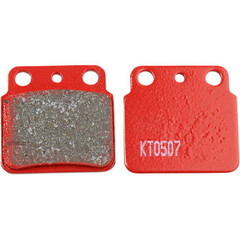 Red rectangular brake pads with three mounting holes, one showing a textured friction surface and the other a smooth.