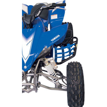 Close-up of the front side of a blue Yamaha ATV, featuring Yamaha Warrior Nerf Bars Black by Motorsport Products, extruded aluminum suspension tubing, part of the body, wheel, and black footrest with netting.