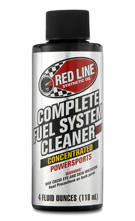 A black and silver 4 fl oz bottle labeled Red Line Complete Fuel System Cleaner; this carburetor and fuel injector cleaner helps improve fuel economy and features Concentrated Powersports in red and yellow text.