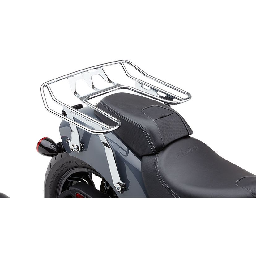 Close-up of a motorcycle’s rear seat area, featuring a chrome Detachable Big-Ass Wrap Around Luggage Rack for Indian Chief 22-24 by Cobra, mounted above the rear fender and behind a black leather seat with visible stitching.
