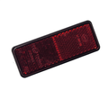 The Rear Reflector by CF Moto is a rectangular reflector with a black border, shown angled on a white background. Its textured surface and subtle text are characteristic of CF Moto UTV parts.