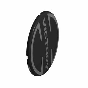 Black round plastic derby cover badge with raised "VICTORY" text and angular design accents.