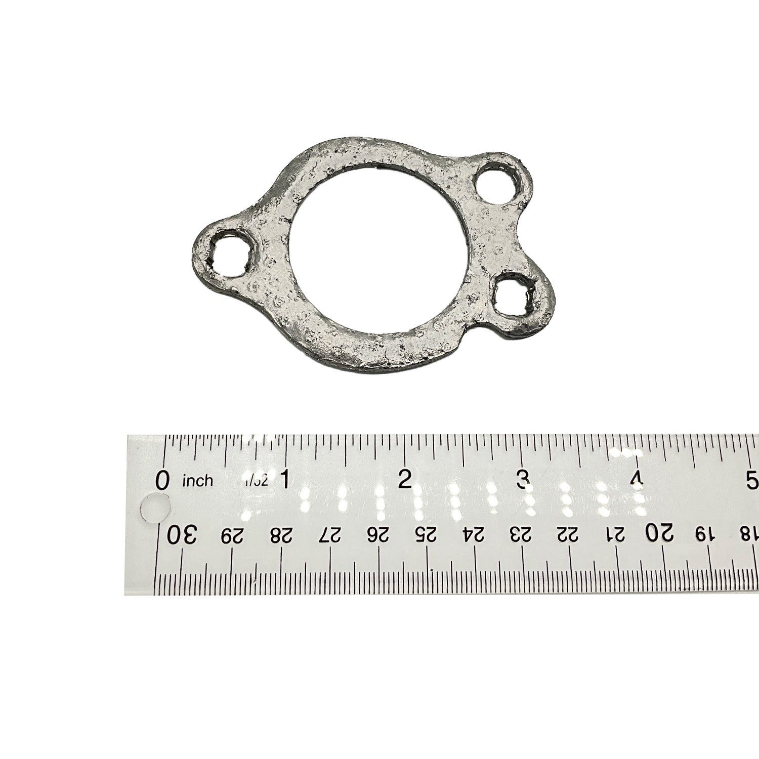 Gray metal exhaust sealing gasket with three mounting holes next to a ruler for scale.