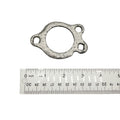 Gray metal exhaust sealing gasket with three mounting holes next to a ruler for scale.
