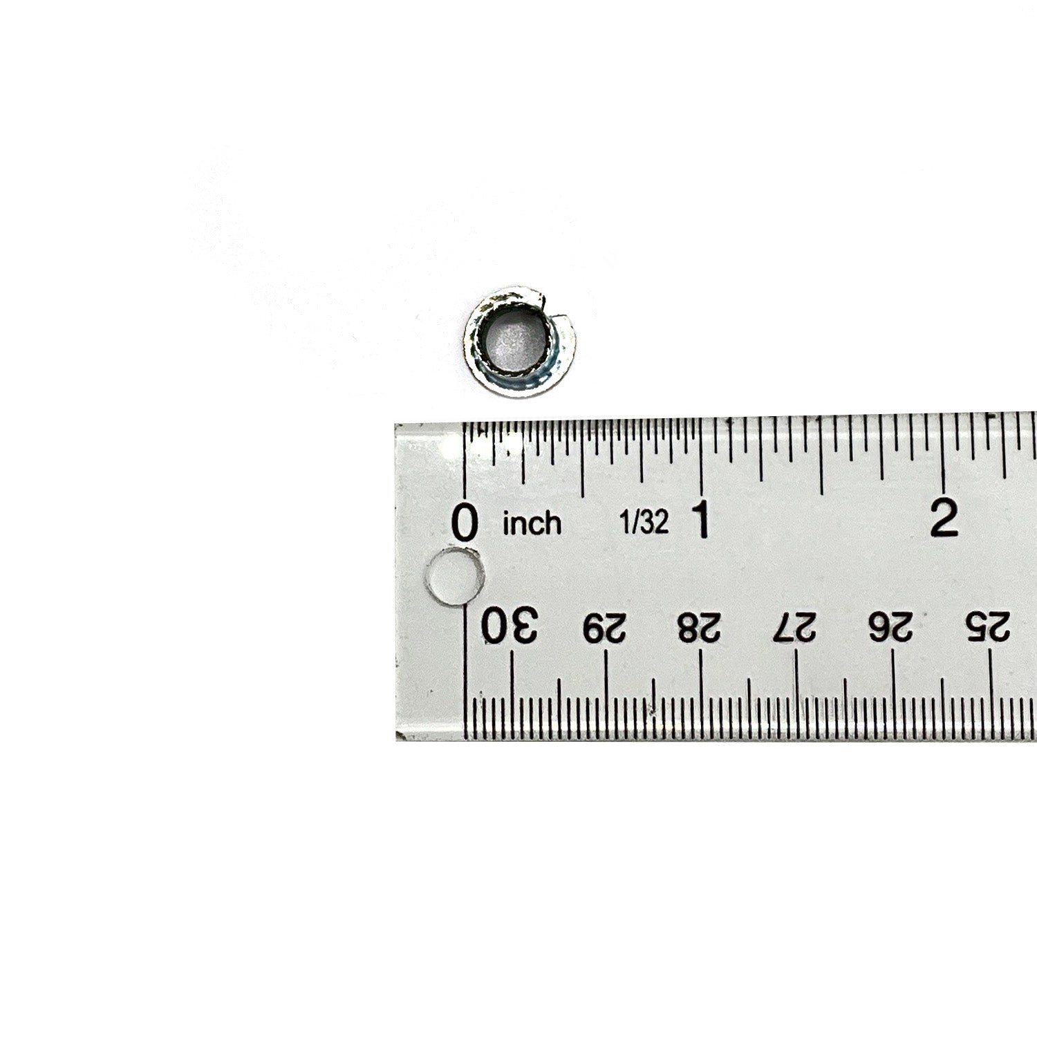 Small silver metal cylindrical door pivot bushing next to a ruler showing measurement in inches.