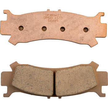 Two Honda Pioneer Standard Brake Pads 1000 by DP Brakes are shown: one displays the smooth backing plate with stamped text, while the other reveals the textured sintered metal friction surface split into two segments.