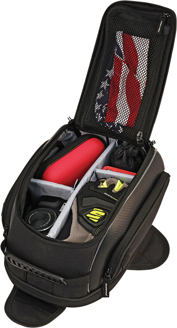 The Commuter Sport Tank Bag by Nelson Rigg, made from durable UltraMax fabric, is shown in black with its top open to reveal organized compartments holding a shoe, red case, gloves, and an American flag item in the lid’s mesh pocket.