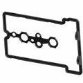 Black rubber valve cover seal gasket with multiple round and oval openings, irregular rectangular shape.