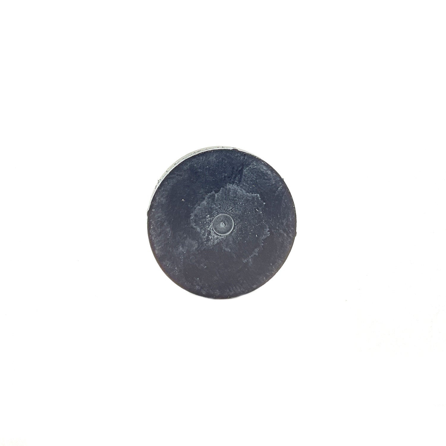 Round black metal clutch button with smooth flat surface and slight wear marks.