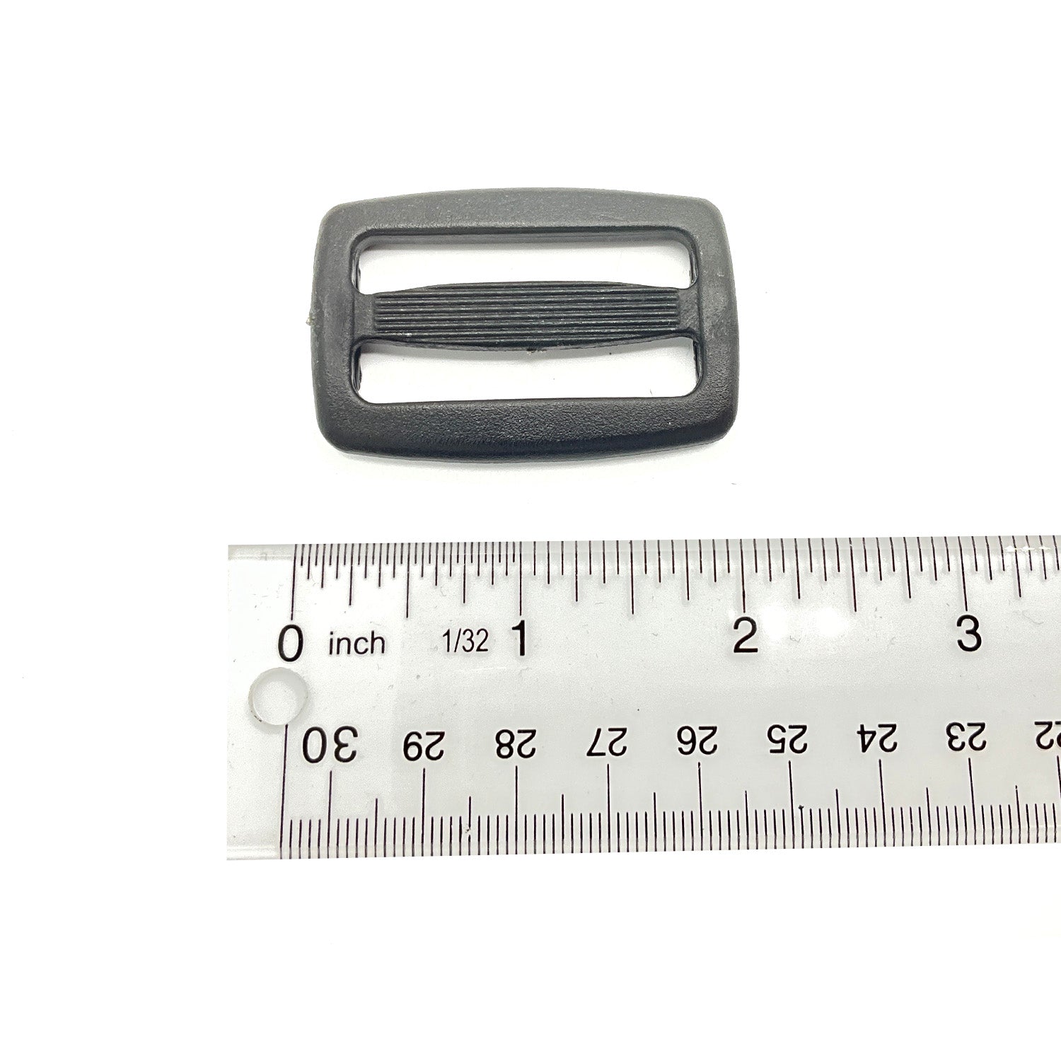 Black rectangular plastic lock ladder with ribbed center bar, shown beside a ruler for size.