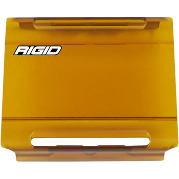 The E Series Lens Cover 4 Amber by Rigid Industries is a rectangular amber snap-on case with RIGID in white on the top left, designed for extra protection and featuring slotted openings at the top and bottom edges.