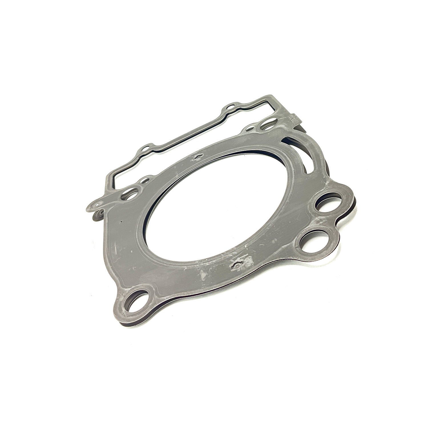 Silver metal cylinder head gasket with multiple bolt holes and a large central circular opening.