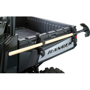 Black metal Polaris Tool Mounts attached to UTV tailgate holding a wooden handle tool horizontally.
