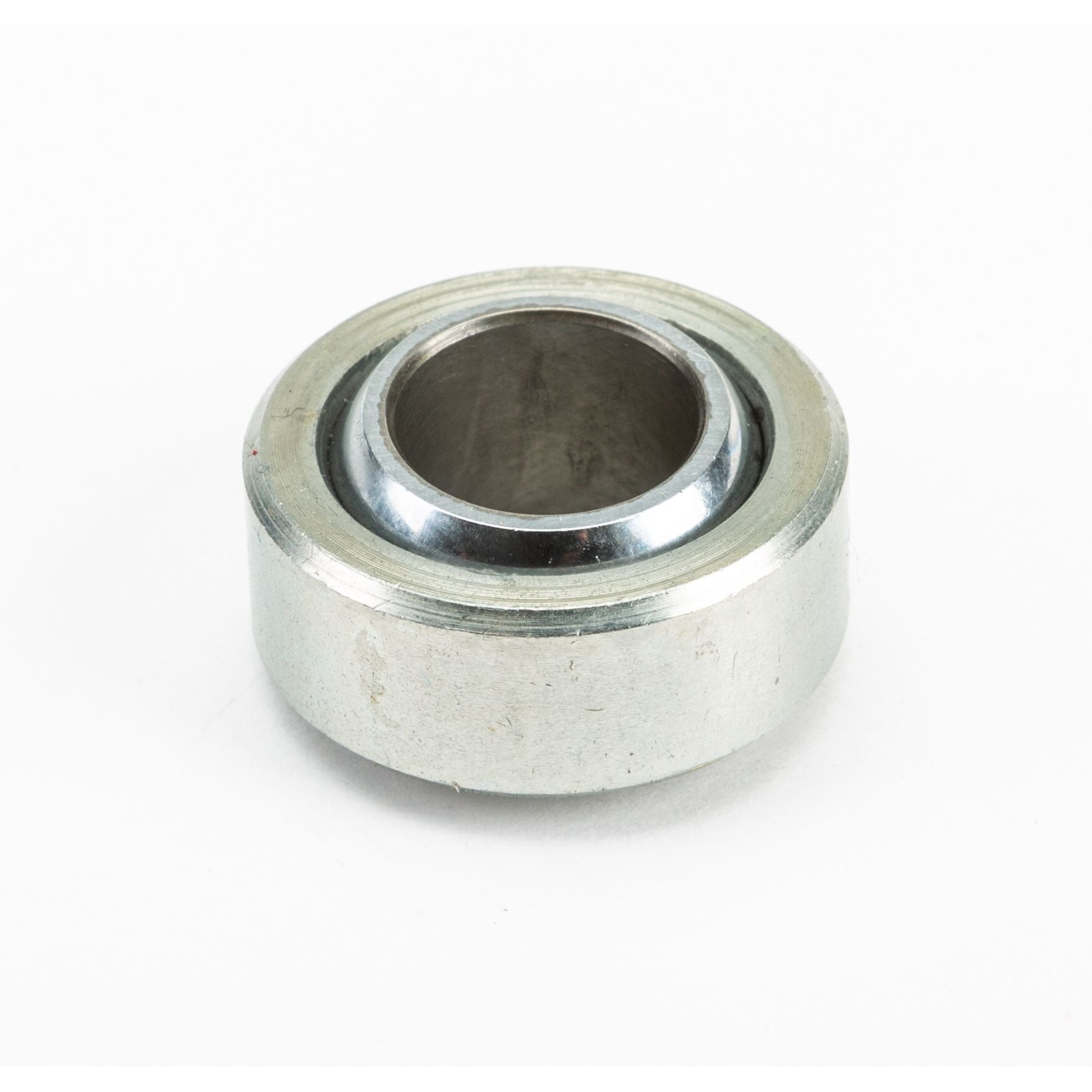 A close-up photo of the Generation 1 Heim Joint by Fox, a metal joint with a hollow circular center, resting on a white background.