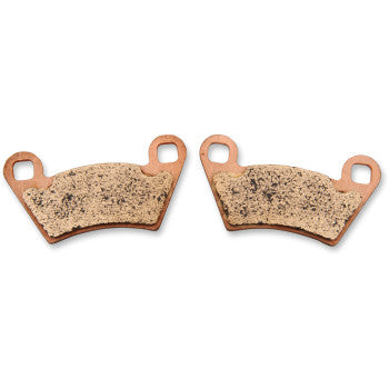 Two Polaris Brake Pads by Sbs with tan, textured friction surfaces and copper-colored backing plates, each featuring two round mounting holes in the top corners, are displayed against a white background.