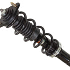Close-up view of a black front gas shock with coiled spring and mounting plate, like the Kawasaki Mule UTV/ATV Front Gas Shock by Bronco, available at Witchdoctors.com, commonly used in suspension systems.
