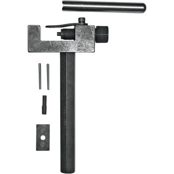 The Chain Tool by Regina is a manual chain breaker for motorcycle assembly, featuring a handle, adjustable clamp, and pin. Displayed with extra pins and components on a white background, its versatile for precise chain maintenance.
