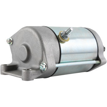 The Starter Motor by Parts Unlimited is a metal cylindrical electric starter with mounting flanges and bolts, shown at an angle, featuring a threaded post, smooth metallic surface, and durable copper bushings—all crafted to OEM specs.