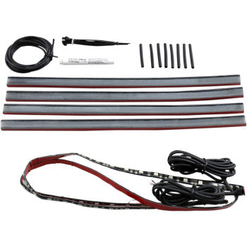 The Indian Wheel Light Kit by Custom Dynamics features four LED strips, a remote control, power cables, connectors, and adhesive backing strips, all neatly arranged on a white background.
