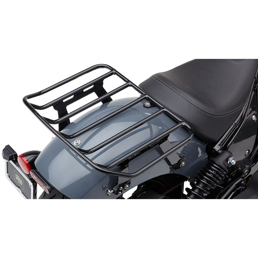 A close-up of the Detachable Big-Ass Luggage Rack, Black for Indian Chief 22-24 by Cobra, made of black metal bars and mounted above the rear wheel behind the black leather seat on a gray bike.