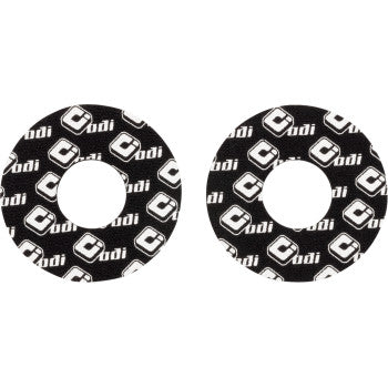 Pair of black circular foam grip donuts with white Odi logo patterns covering the surface.