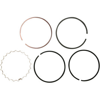 Five Wiseco Ring Set piston rings are arranged on a white background: four solid, open-gapped rings and one with a wavy, textured edge.