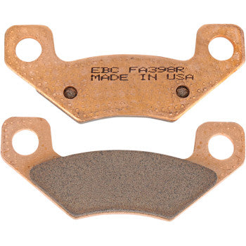 Copper-colored sintered brake pads with black friction surface, two mounting holes on each pad, EBC branding and model info.