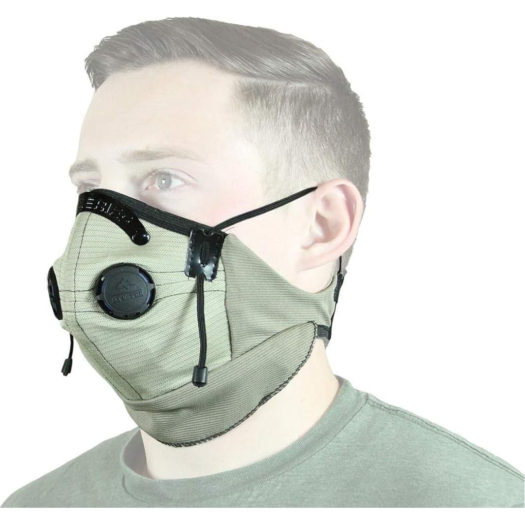 A person wears the Pro Series Rider Dust Mask (Tan) by ATV-TEK, featuring two black exhaust valves and adjustable ear straps, shown from the shoulders up against a white background.