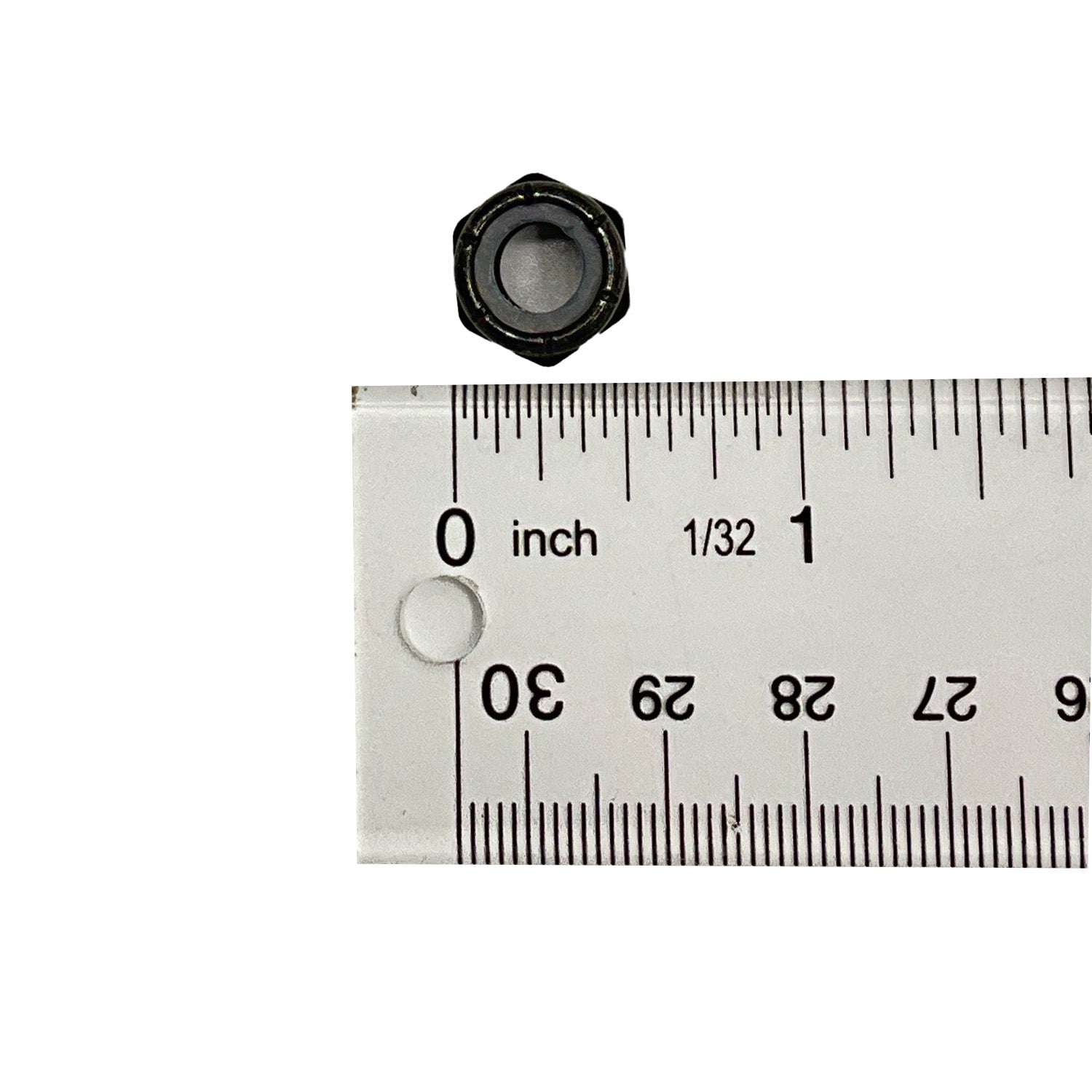 Black hexagonal nylon lock nut next to white ruler showing size just under 0.5 inch.