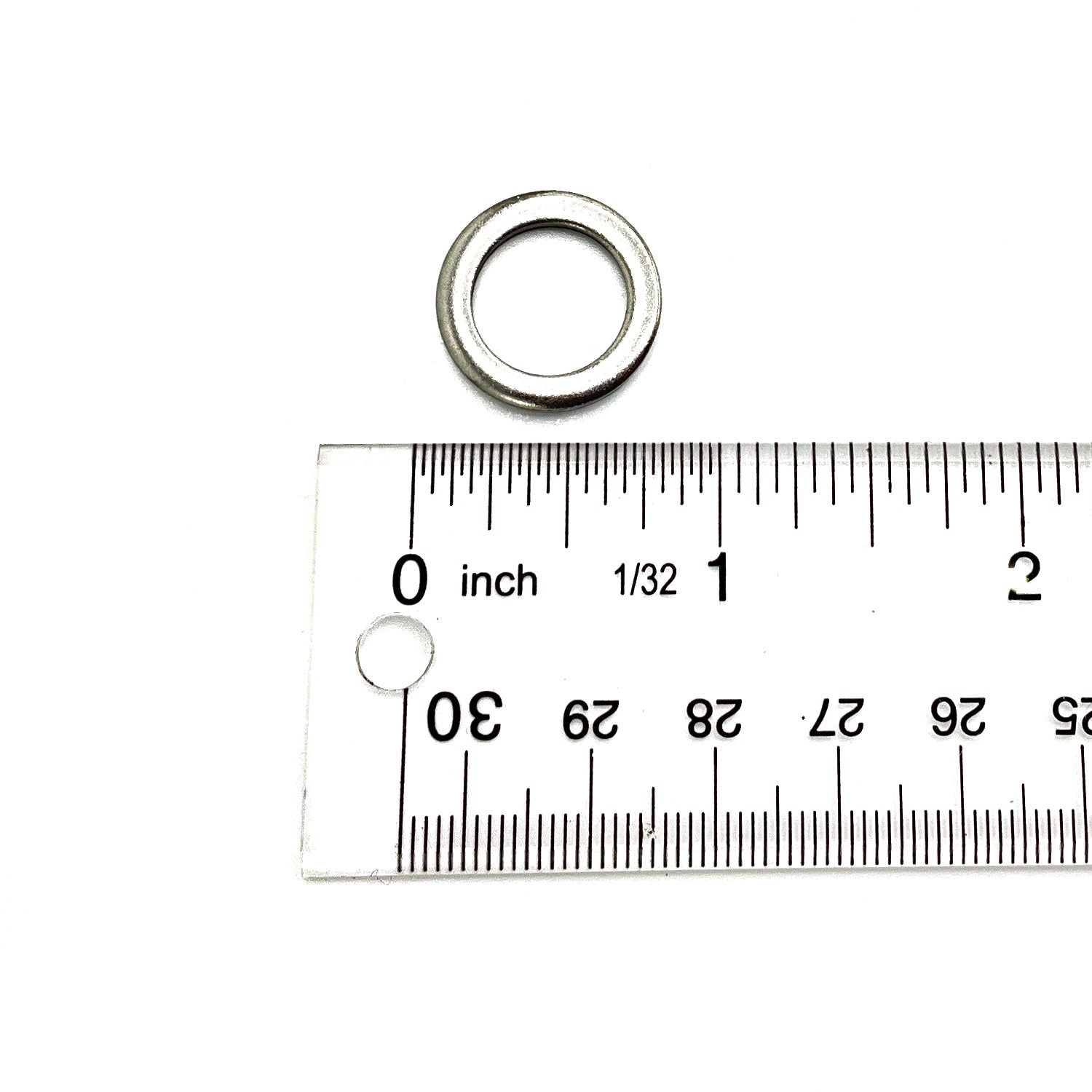 Small silver metal washer measuring approximately half an inch in outer diameter against a white background with a ruler.
