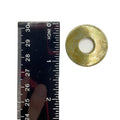 Round metallic washer with a central hole, next to a black ruler marked in inches and centimeters.
