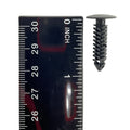 Black plastic push rivet clip with serrated stem, shown next to black ruler for size reference.