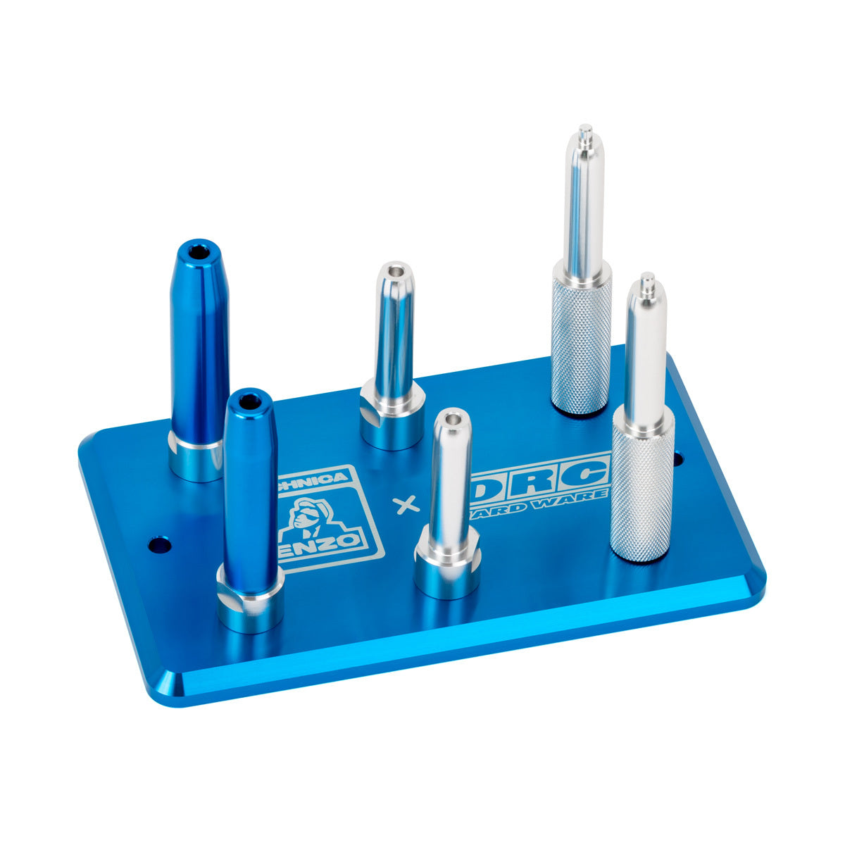 The Rear Shock Valving Plate by DRC features a blue rectangular metal base with six uniquely shaped metal pegs in silver and blue, arranged upright; logos and text are printed on the base.