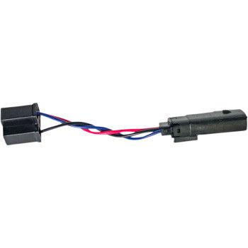 The Indian Headlamp Adapter by Custom Dynamics features a black connector with two black sockets, joined by red, blue, and black wires to a single black cylindrical plug.