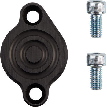 The ATV Brake Block Off Black by T.M. Designworks is a black, round CNC billet alloy plate with two mounting holes and two silver screws, shown on a white background.